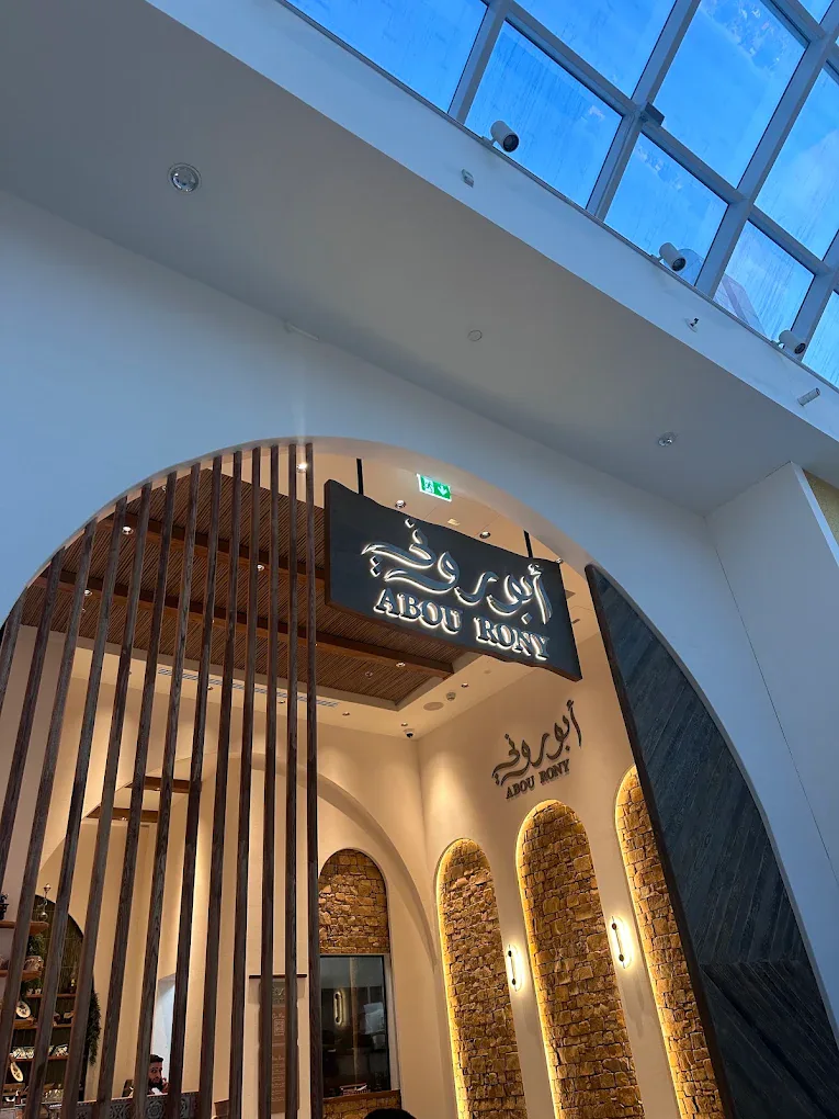 Abou Rony restaurant entrance in JVC, Dubai, with illuminated bilingual logo.