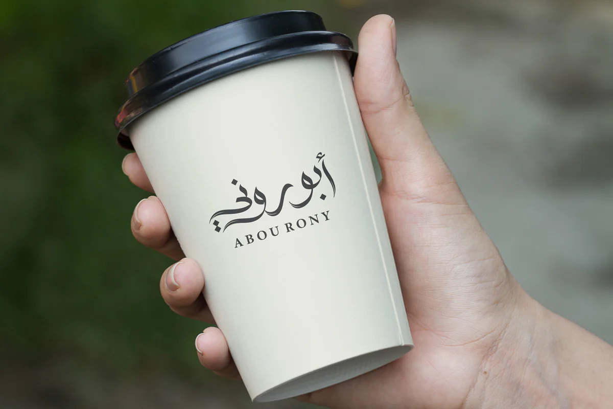 Concept mockup of the Abou Rony bilingual logo on a takeaway coffee cup.